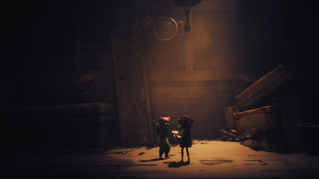 Little Nightmares 3 screenshot. It shows the main characters standing in a dimly lit corridor