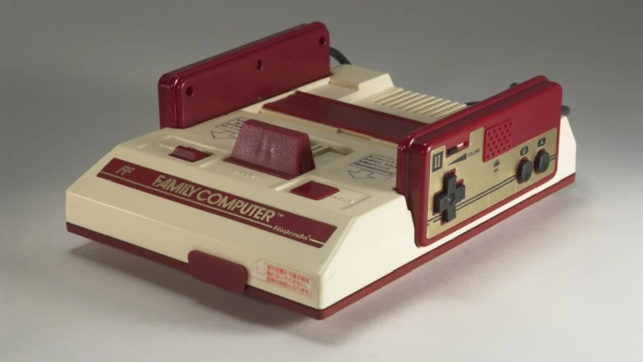 Foto met de Famicom console in beeld met een grijze achtergrond.
